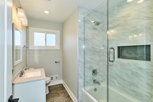 a bathroom with a sink a toilet and shower