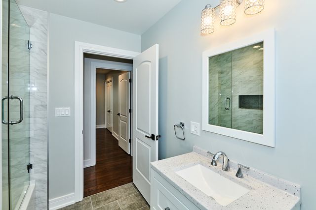 a bathroom with a sink a mirror and a shower