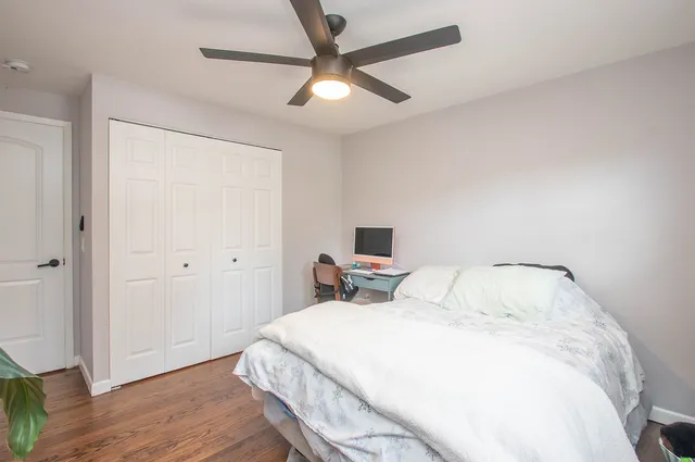 a bedroom with a bed and a ceiling fan