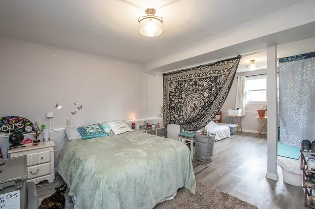 a bed sitting in a bedroom next to a window