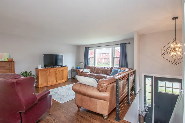 a living room with furniture a flat screen tv and a window