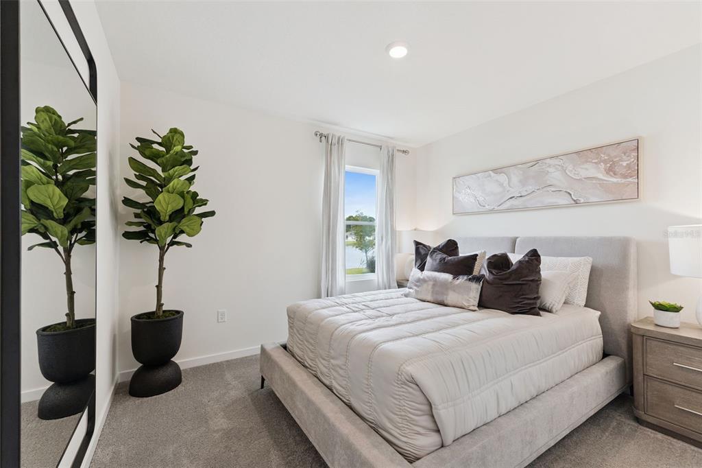 2833 House Finch Road St. Cloud, FL 34773 - Photo 24 of 70 a bedroom with a bed potted plant and a potted plant