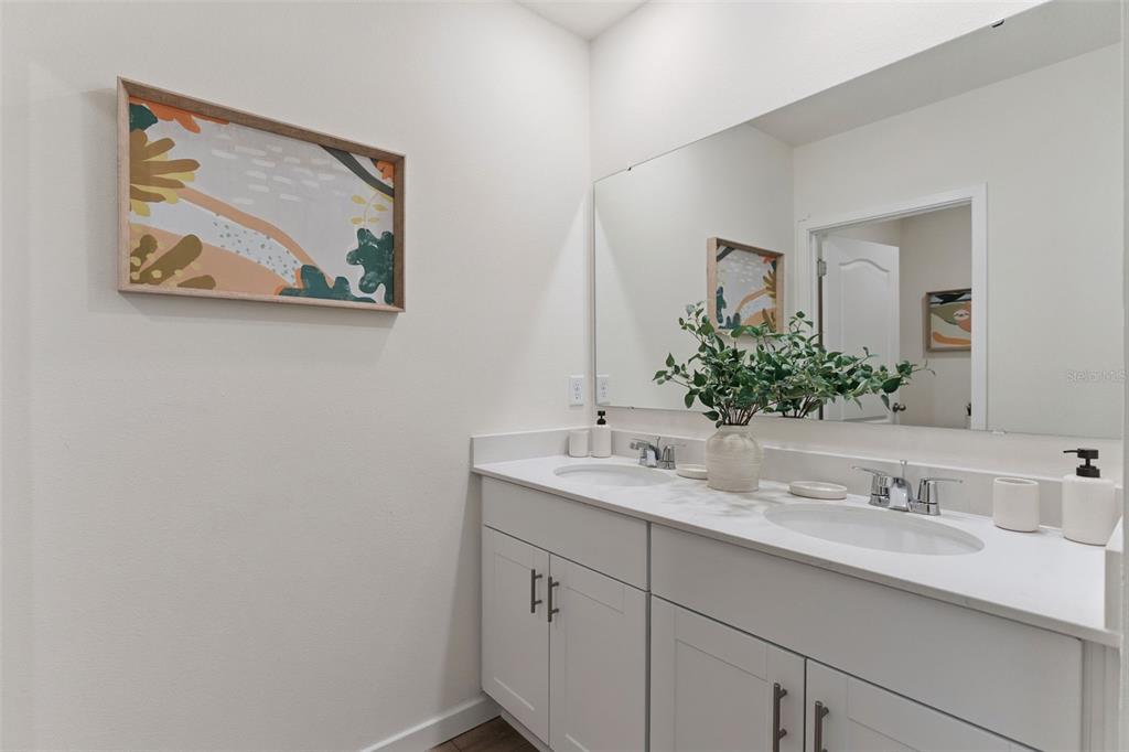 2833 House Finch Road St. Cloud, FL 34773 - Photo 29 of 70 a bathroom with a granite countertop sink mirror and vanity