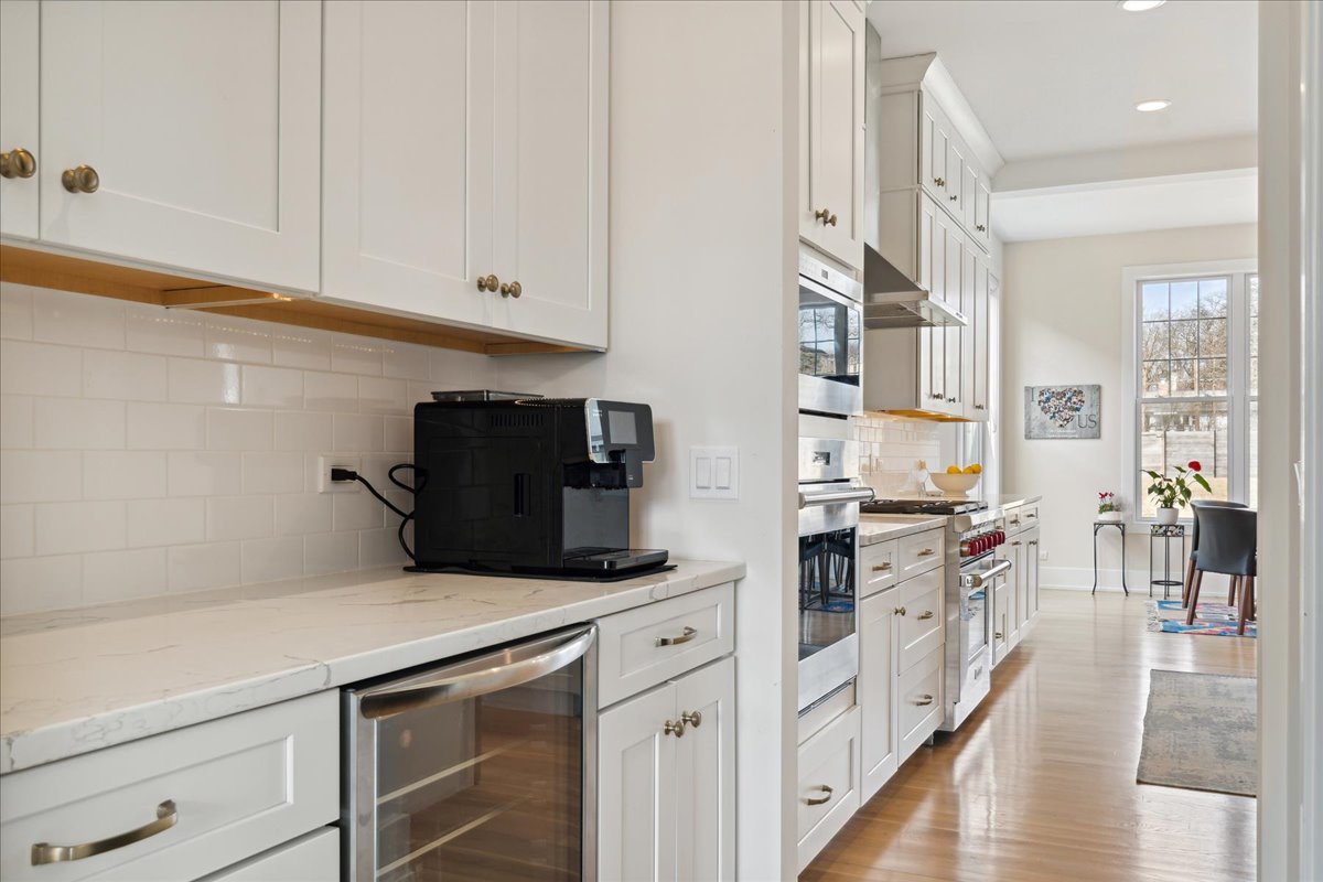 761 County Line Road Highland Park, IL 60035 - Photo 13 of 36 a kitchen with stainless steel appliances white cabinets and wooden floor