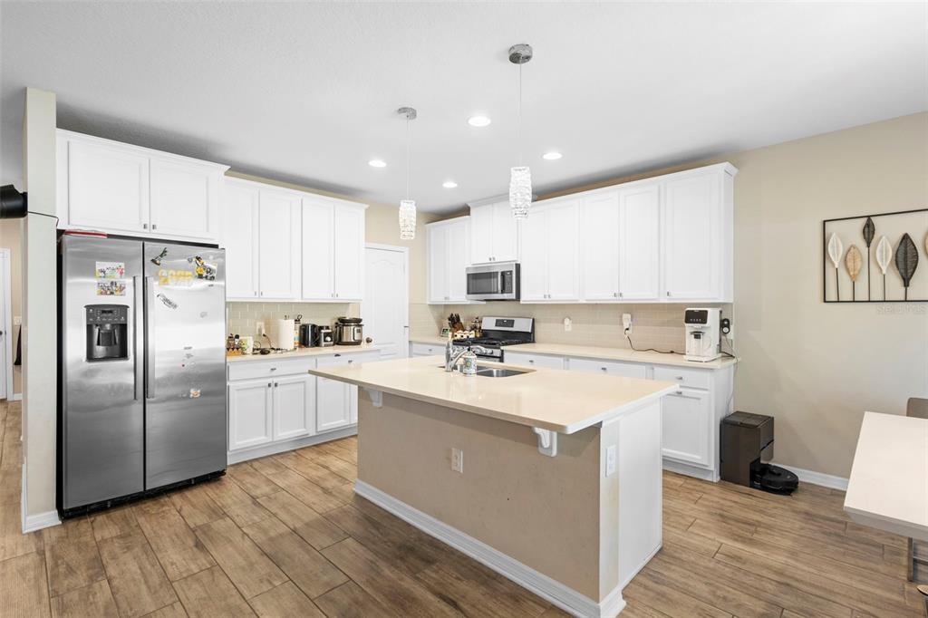 3937 Ceremony Cove Sanford, FL 32771 - Photo 3 of 51 a kitchen with a sink stainless steel appliances and white cabinets