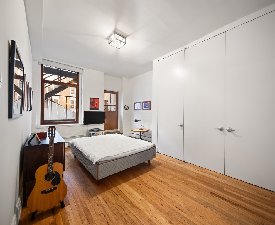 124 West 24th Street, Unit 2B Manhattan, NY 10011 - Photo 5 of 7 a bedroom with a bed and wooden floor