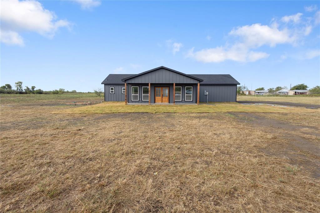 View of front of property featuring a front lawn and covered porch