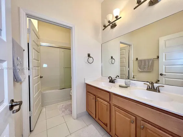 a bathroom with a double vanity sink a mirror and a bathtub