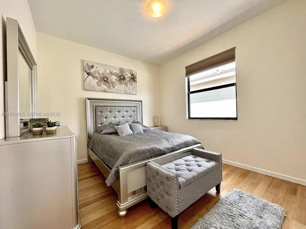 a bedroom with a bed lamp and a window
