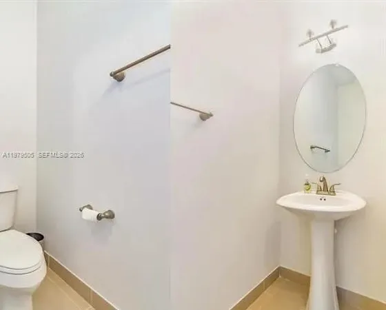 a bathroom with a sink toilet and a mirror