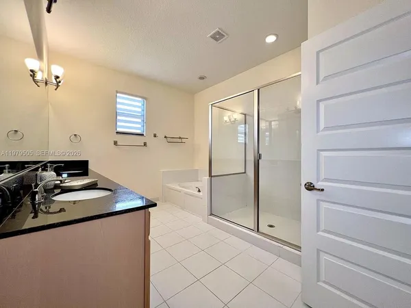 a bathroom with a shower sink and mirror