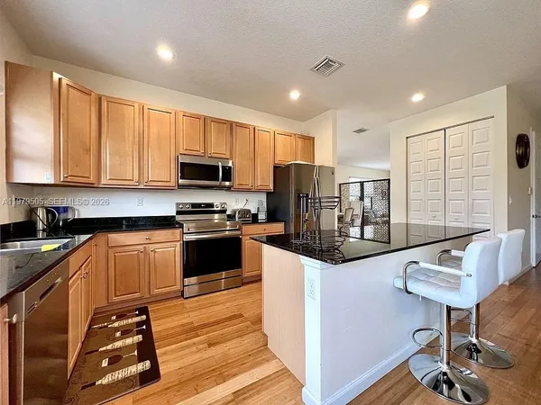 a kitchen with granite countertop a stove and a wooden floors