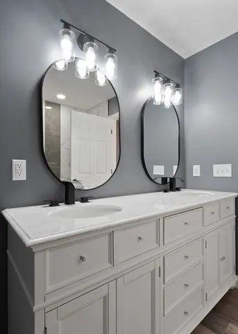 a bathroom with double vanity sinks and a mirror