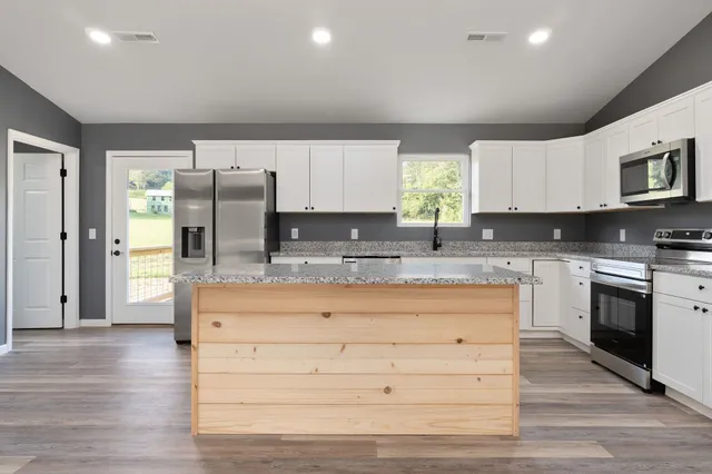 a kitchen with granite countertop wooden cabinets and stainless steel appliances