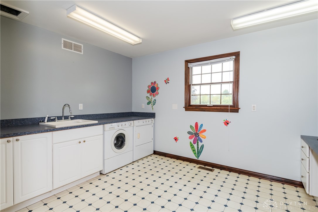 9981 Ridge Acres Lane Englewood, OH 45322 - Photo 26 of 73 Functional laundry space featuring a sink, washer, and dryer for everyday convenience.