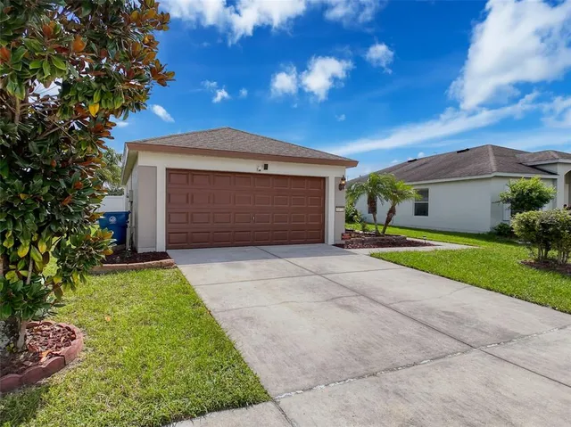 a front view of a house with a yard and garage