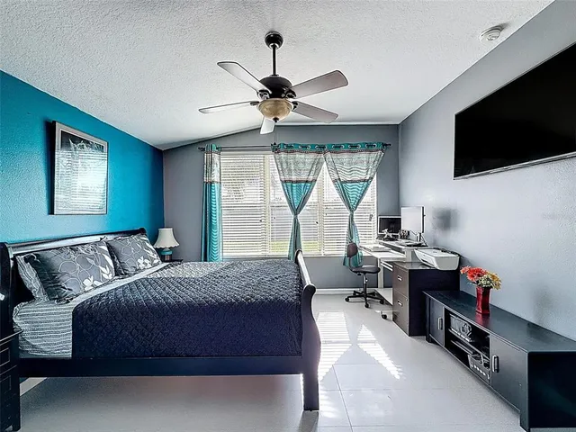 a workspace with a flat screen tv and a ceiling fan