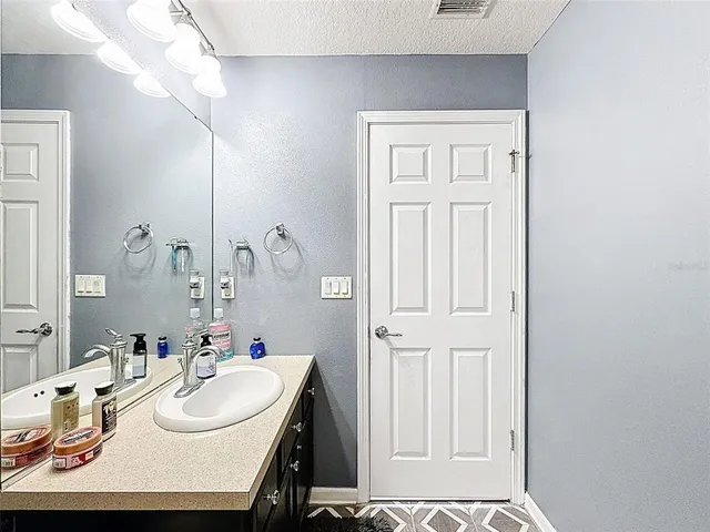 a view of a patio with table and chairs potted plants and palm tree