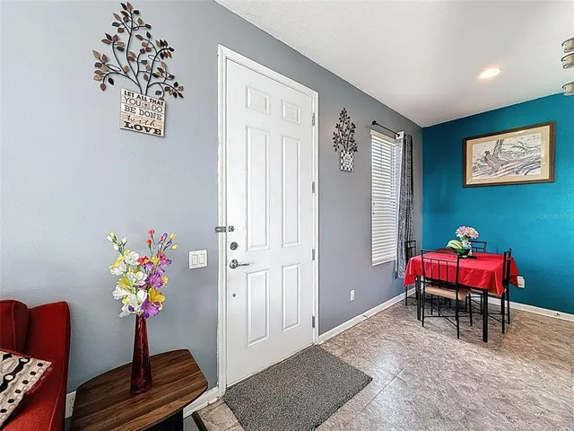 a kitchen with stainless steel appliances kitchen island granite countertop a refrigerator a sink a stove a dining table and chairs