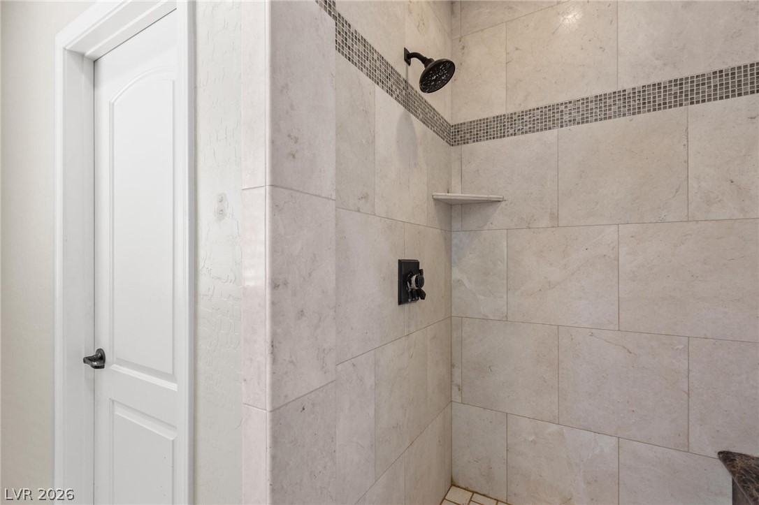8431 Durango Ranch Court Las Vegas, NV 89113 - Photo 33 of 49 This modern bathroom features a tiled shower with a sophisticated showerhead.