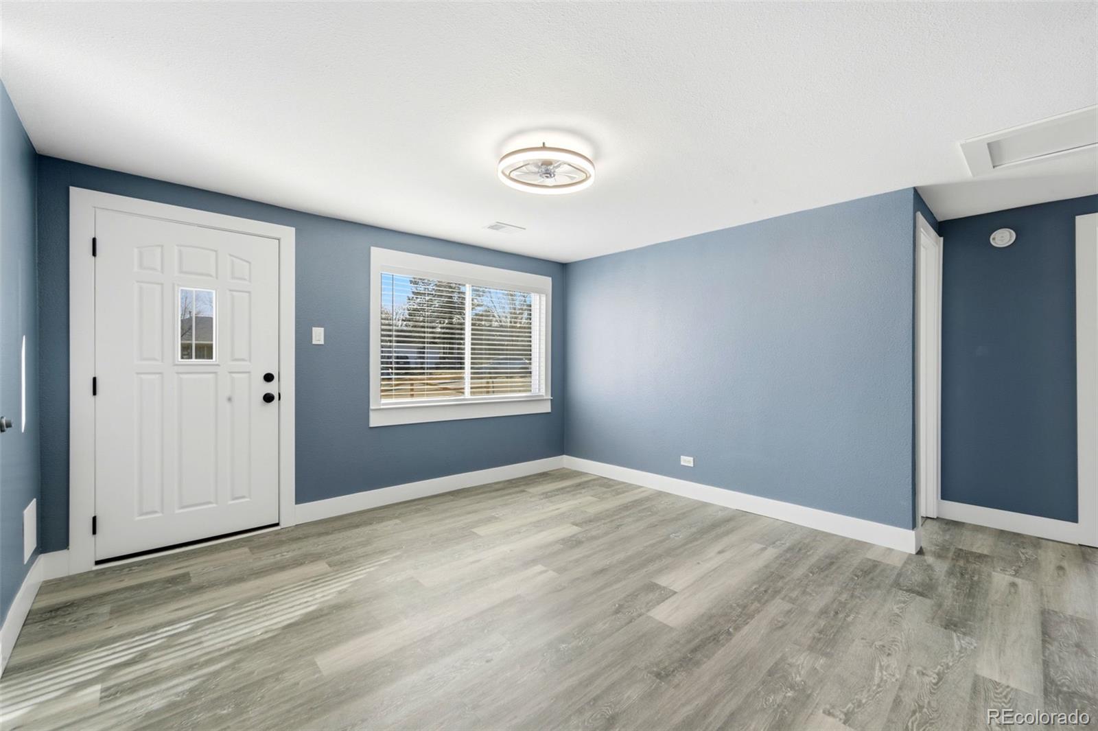 4933 Steele Street Denver, CO 80216 - Photo 4 of 31 wooden floor in an empty room with a window
