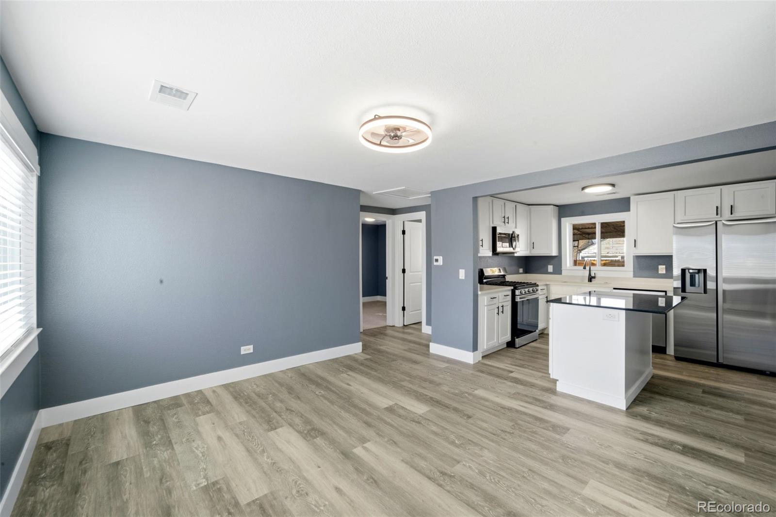 4933 Steele Street Denver, CO 80216 - Photo 6 of 31 a kitchen with a refrigerator and a stove top oven