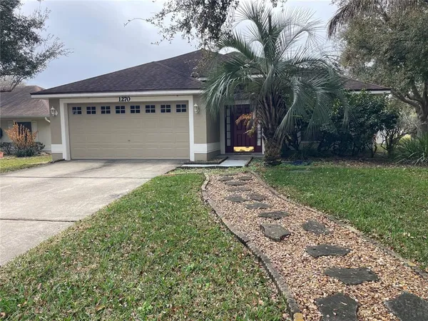 a front view of a house with a garden and yard