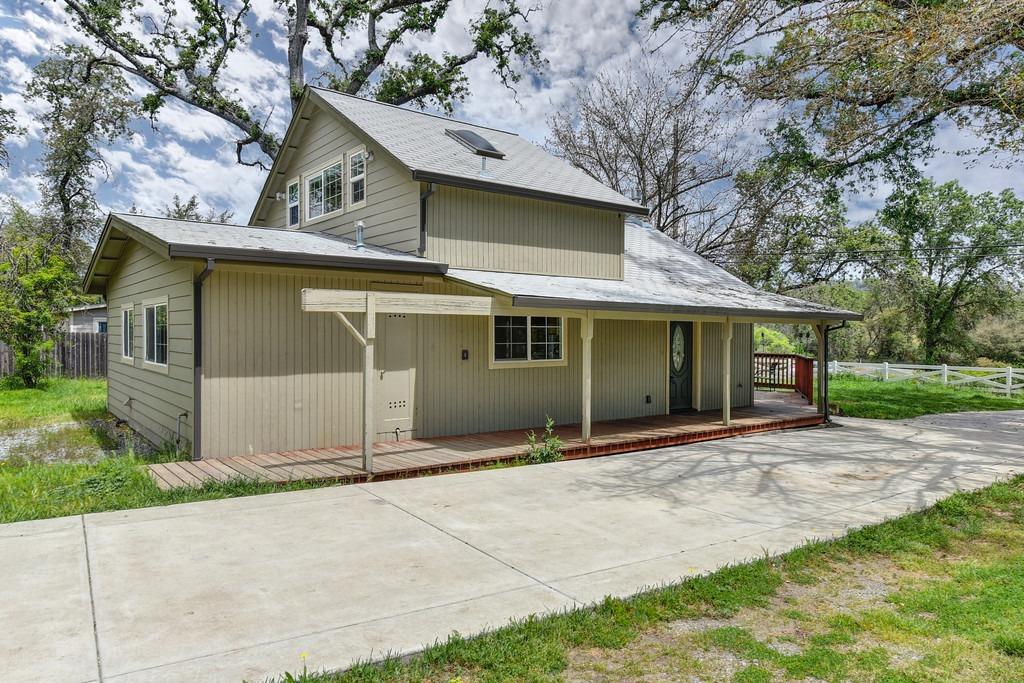 4524 Salmon Falls Road Pilot Hill, CA 95664 - Photo 16 of 47 a front view of a house with a garden and trees