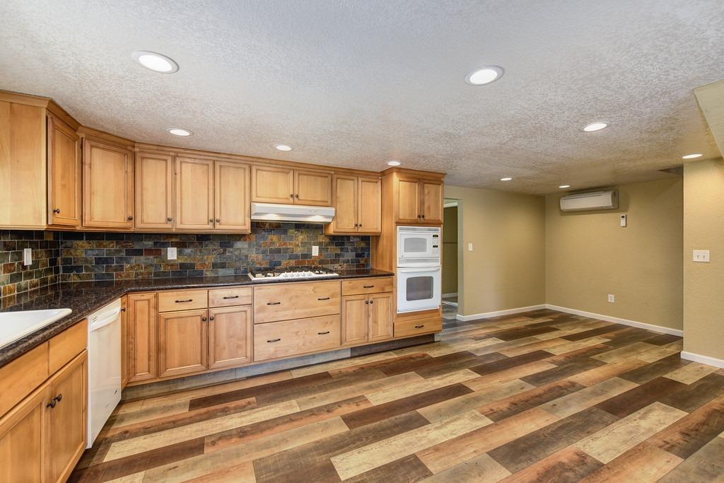 4524 Salmon Falls Road Pilot Hill, CA 95664 - Photo 26 of 47 a large kitchen with granite countertop white cabinets and stainless steel appliances