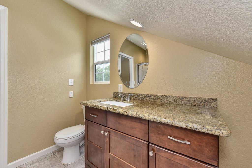 4524 Salmon Falls Road Pilot Hill, CA 95664 - Photo 39 of 47 a bathroom with a granite countertop toilet sink and mirror