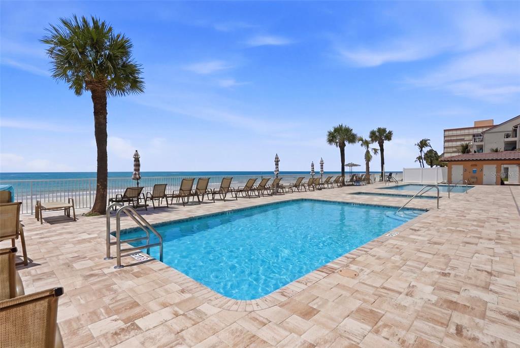16326 Gulf Boulevard, Unit 307 Redington Beach, FL 33708 - Photo 37 of 43 a view of a swimming pool with a table and chairs
