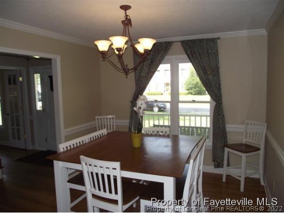 7796 Trappers Road Fayetteville, NC 28311 - Photo 9 of 24 a view of a dining room with furniture wooden floor and chandelier