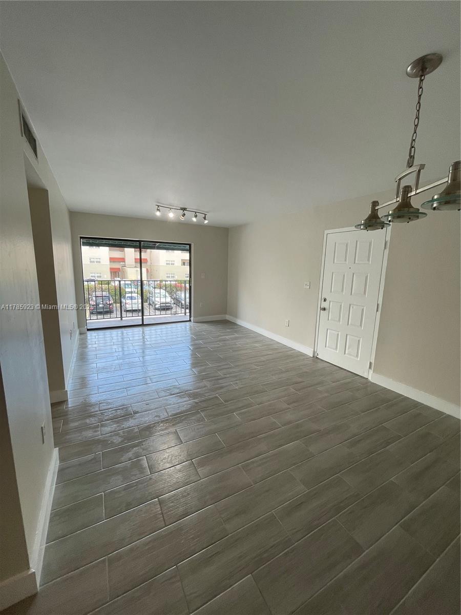 West End Miami, FL 33193 - Photo 2 of 12 an empty room with wooden floor and windows