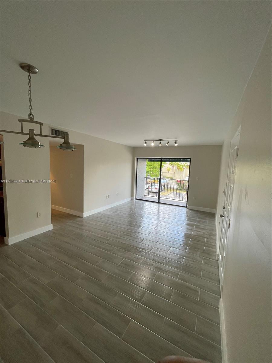 West End Miami, FL 33193 - Photo 3 of 12 an empty room with wooden floor and windows