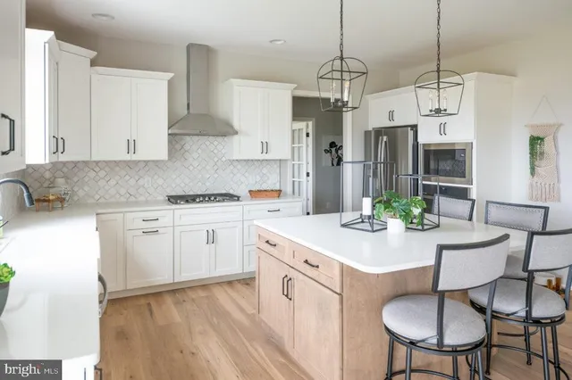 a kitchen with stainless steel appliances a white cabinets and wooden floor