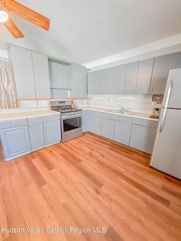 a kitchen with granite countertop a sink stove and refrigerator