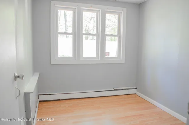 a view of a small space with wooden floor and a window