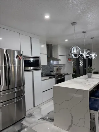 a kitchen with cabinets and chairs