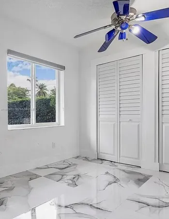 a view of a room that has a window and a ceiling fan