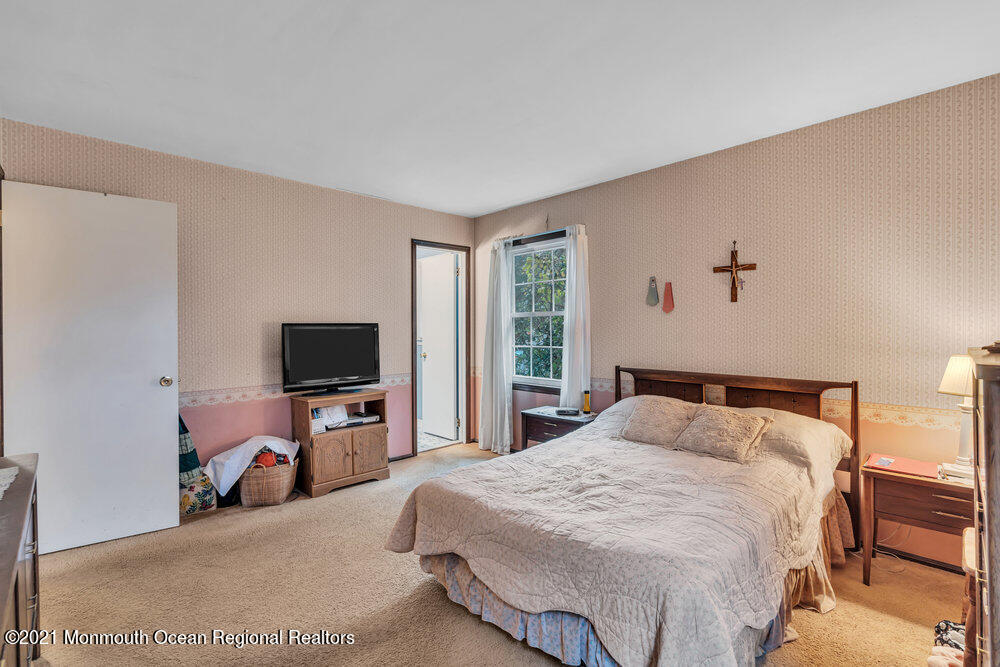 146 Cedar Swamp Road Jackson, NJ 08527 - Photo 18 of 48 a bedroom with a bed and a flat tv screen on wall
