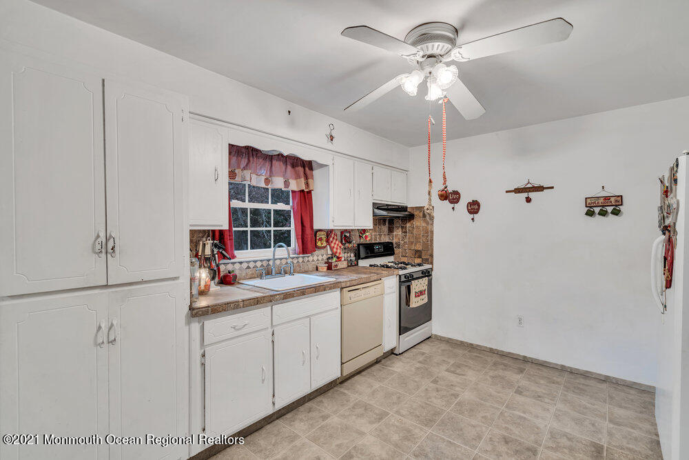 146 Cedar Swamp Road Jackson, NJ 08527 - Photo 29 of 48 a kitchen with a sink a refrigerator and cabinets