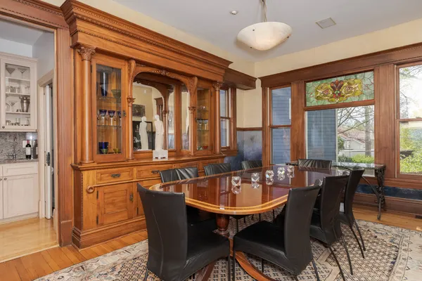 a kitchen with stainless steel appliances granite countertop a stove top oven a sink a dining table and chairs