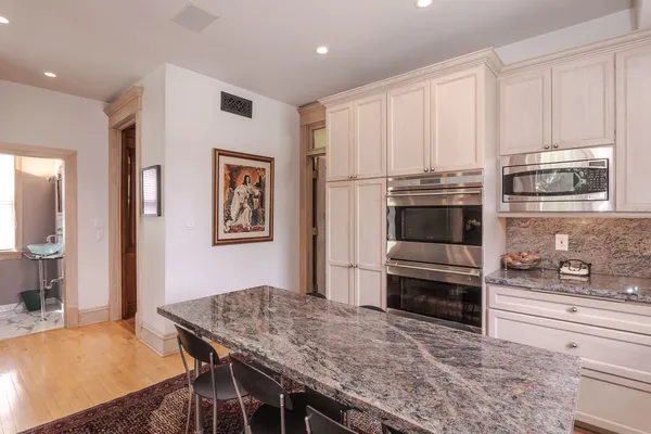 a bedroom with a bed and a large mirror next to a window