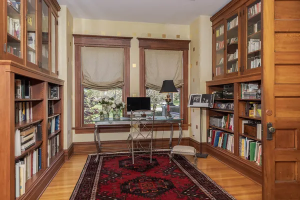 a living room with large windows and a rug