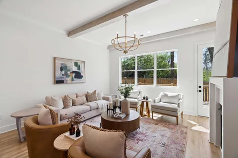 a living room with furniture a chandelier and a dining table