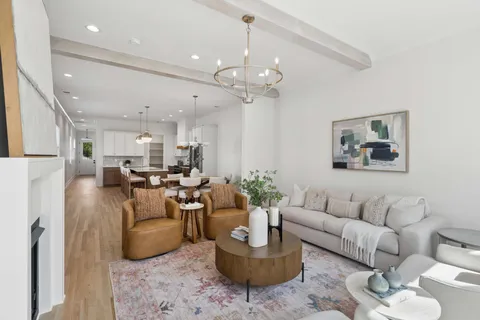 a living room with furniture a chandelier and a rug