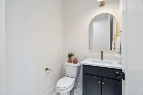 a bathroom with a sink vanity mirror and toilet