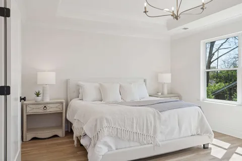 a bedroom with a bed and large windows