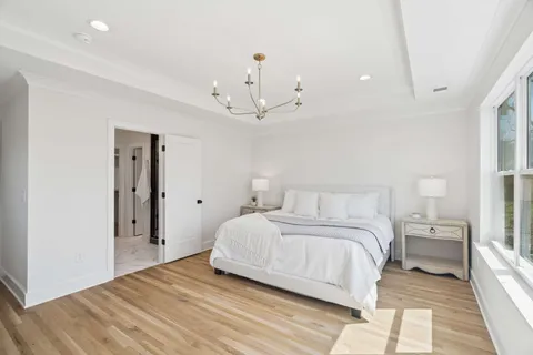 a bedroom with a bed and a chandelier