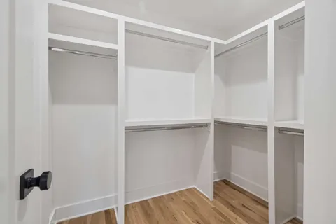 a view of walk in closet with empty racks